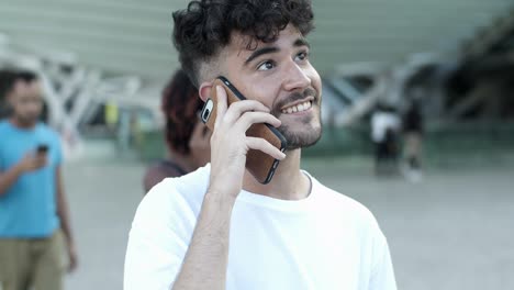 Smiling-young-man-talking-on-smartphone